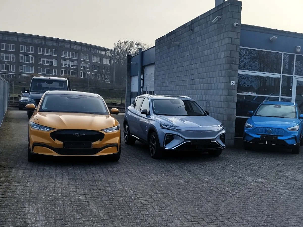 Gele Ford Mustang en andere auto’s voor het pand van Autohandel Wolters in Venlo